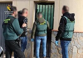 La Guardia Civil, con uno de los detenidos, en un registro domiciliario.