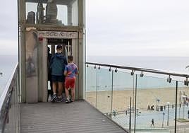Unos turistas utilizan el ascensor.