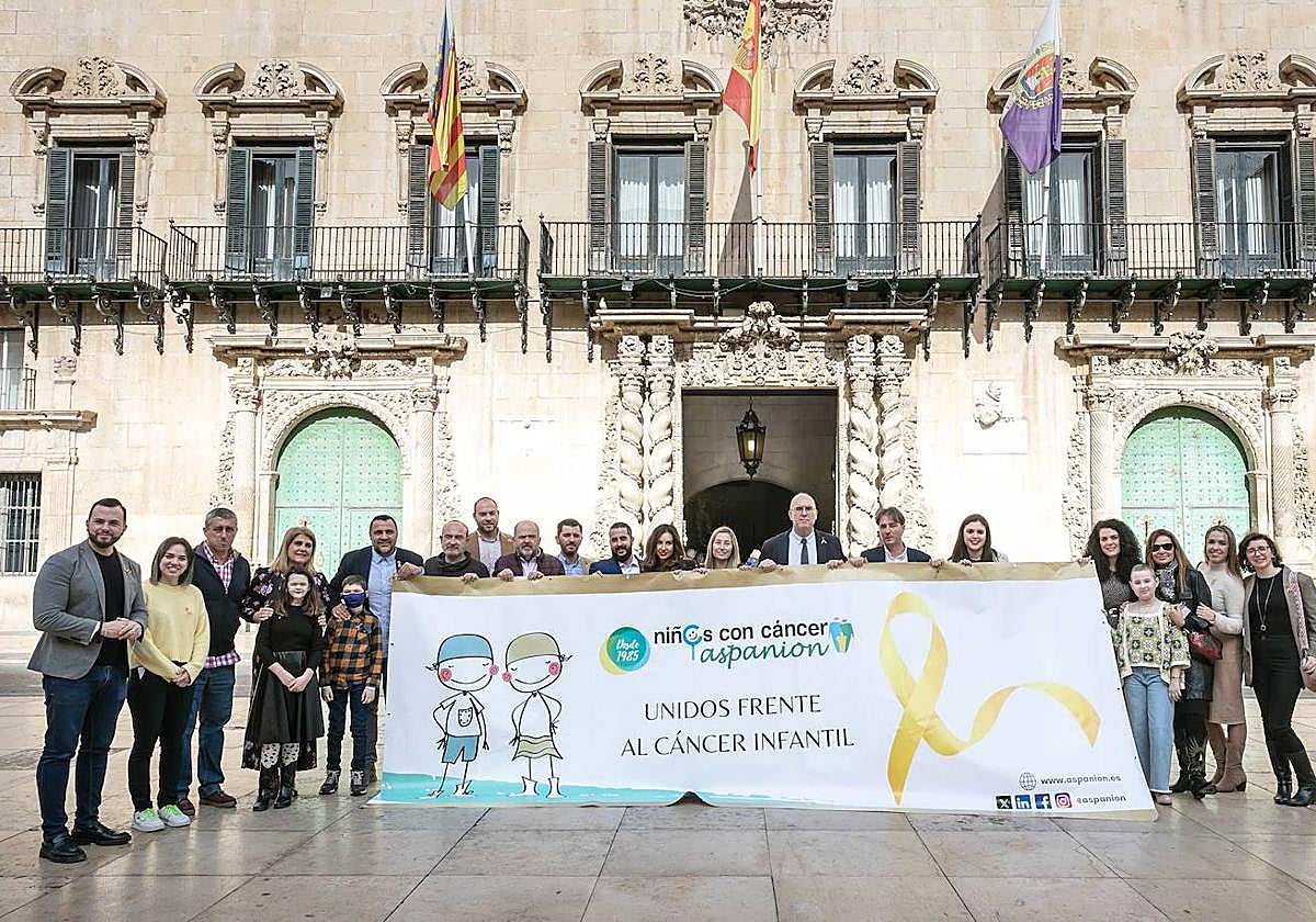 Despliegue de una gran pancarta con un lazo dorado en la plaza del Ayuntamiento