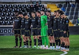 Los jugadores del Intercity guardan un minuto de silencio como recuerdo a las víctimas del incendio del barrio de Campanar en Valencia.