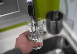 Una persona se llena un vaso de agua del grifo.