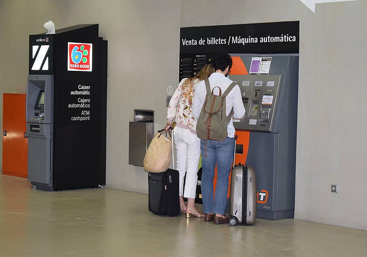Dos usuarios adquiriendo un título de transporte para el TRAM d'Alacant.
