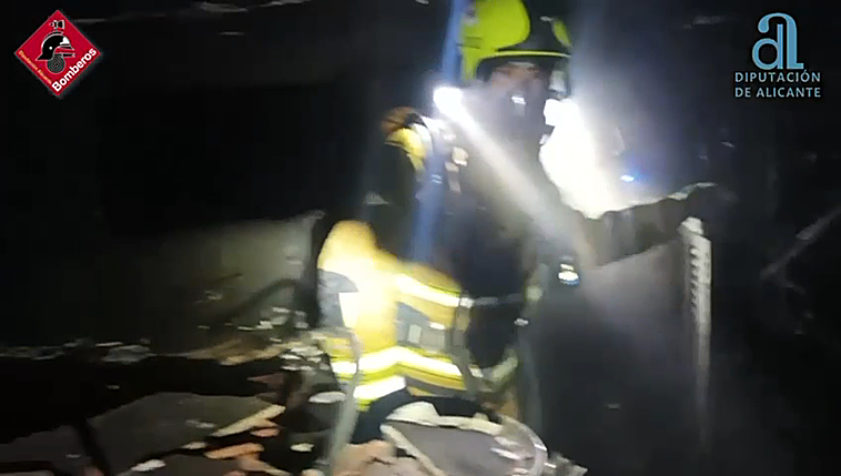 Los bomberos actuando en el local incendiado en Santa Pola.