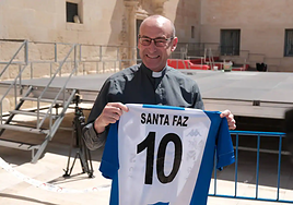 Joaquín López, capellán del Hércules, con una camiseta firmada por todos los jugadores.