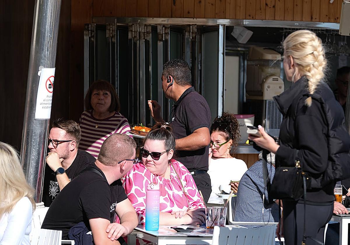 Un camarero atiende a turistas en Alicante.