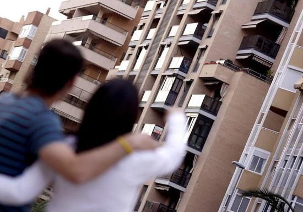 Una pareja joven observa una vivienda en venta en Alicante.