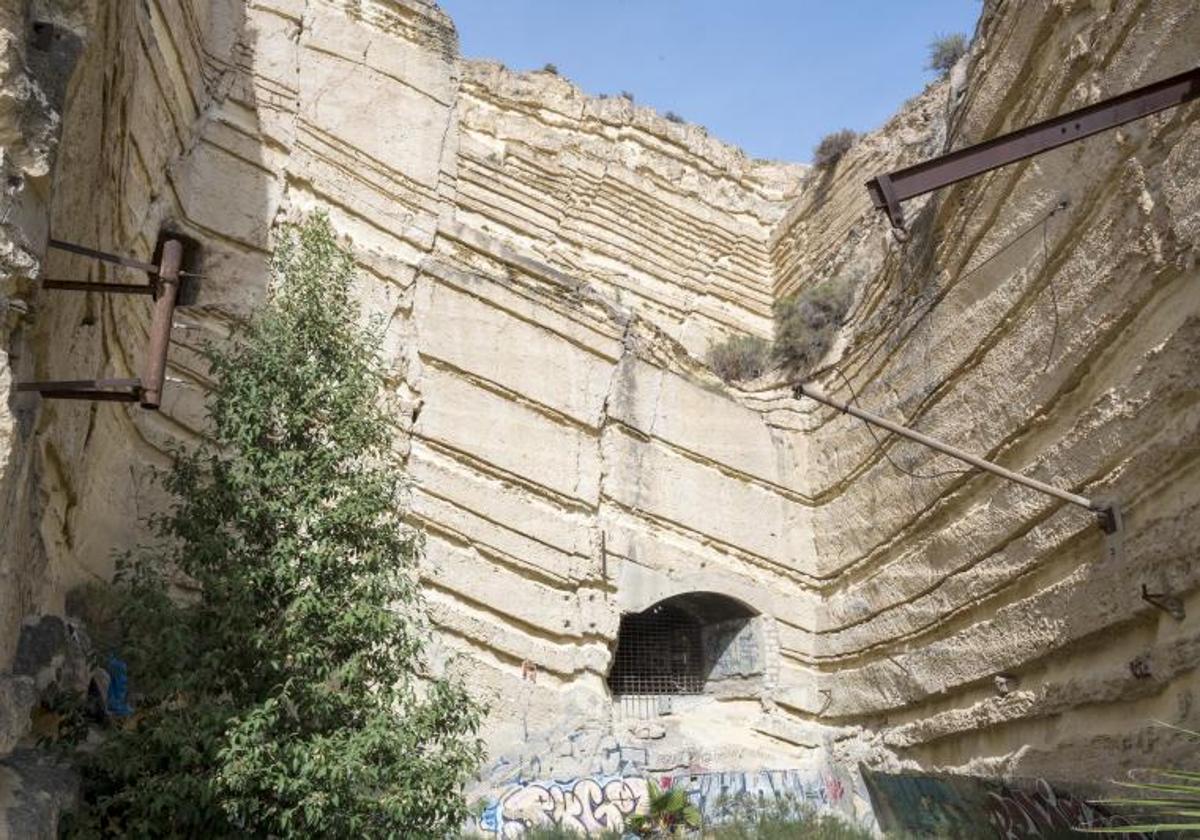 Puerta de acceso a la refinería escondida en la montaña de Alicante.