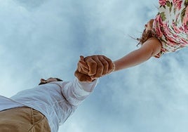 Una pareja pasea cogida de la mano.