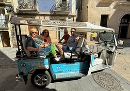 Unos turistas en uno de los 'tuc tuc' que se ofertan en Alicante.