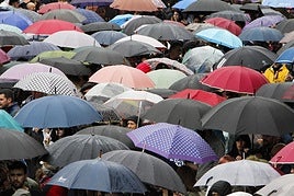 Multitud con paraguas.