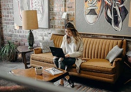 Una clienta trabaja desde el recibidor de un hotel.