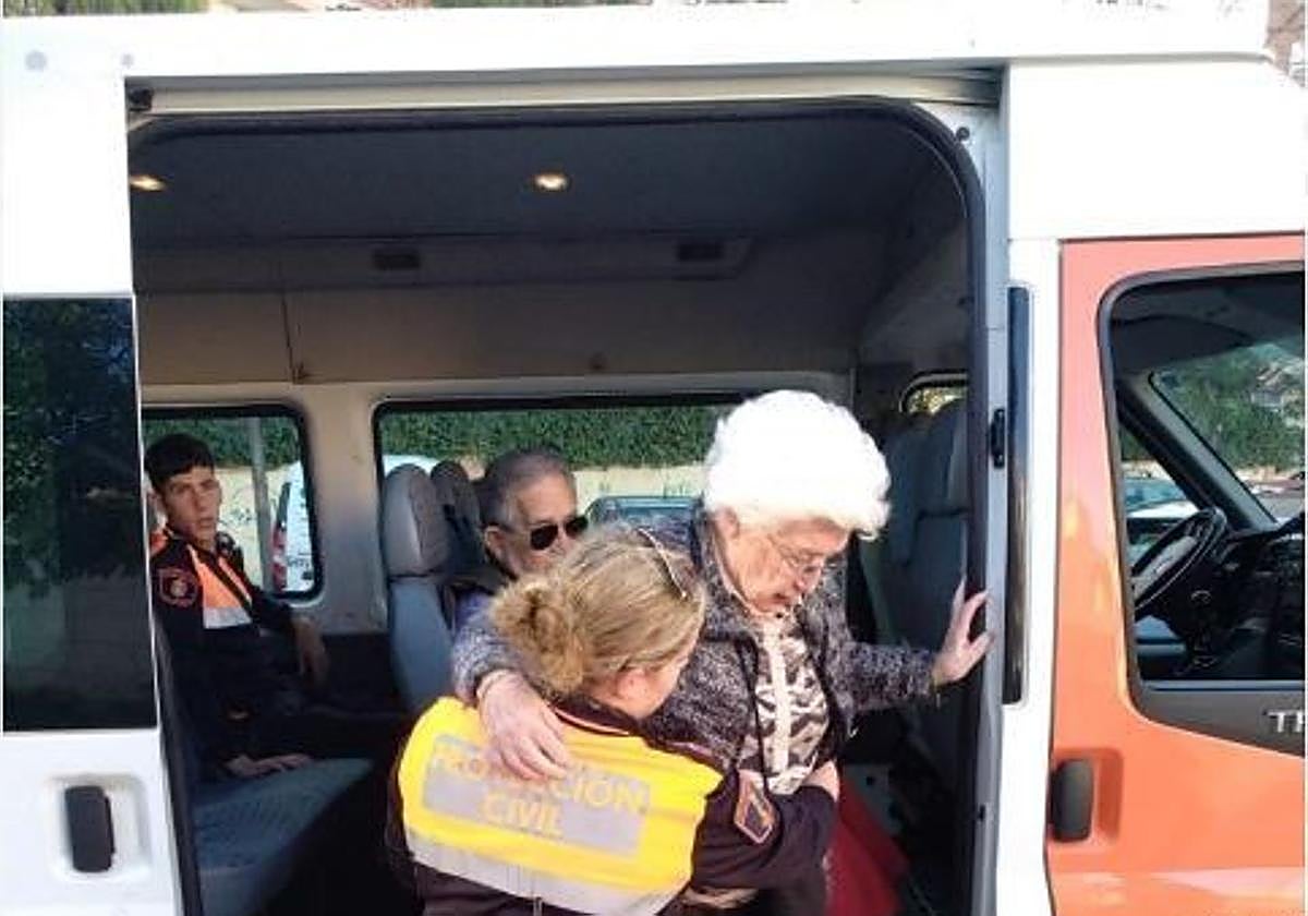 Protección Civil ayuda a bajar de la furgoneta a una persona mayor.