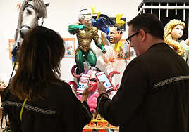 Varias presonas prueban la aplicación de la exposición del Ninot.