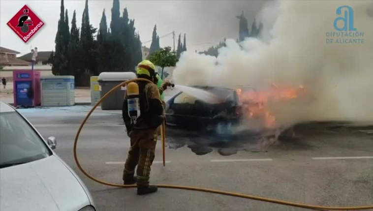 Los bomberos extinguen el incendio de un coche.