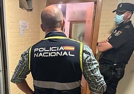 Dos agentes de Policía Nacional en la puerta de los sospechosos del crimen del torso quemado de Alicante.