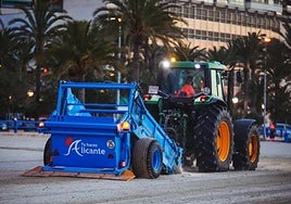 Equipo mecanizado limpiando la playa del Postiguet.