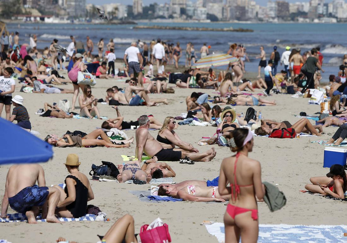 Personas disfrutando de un día con calor en el Postiguet.