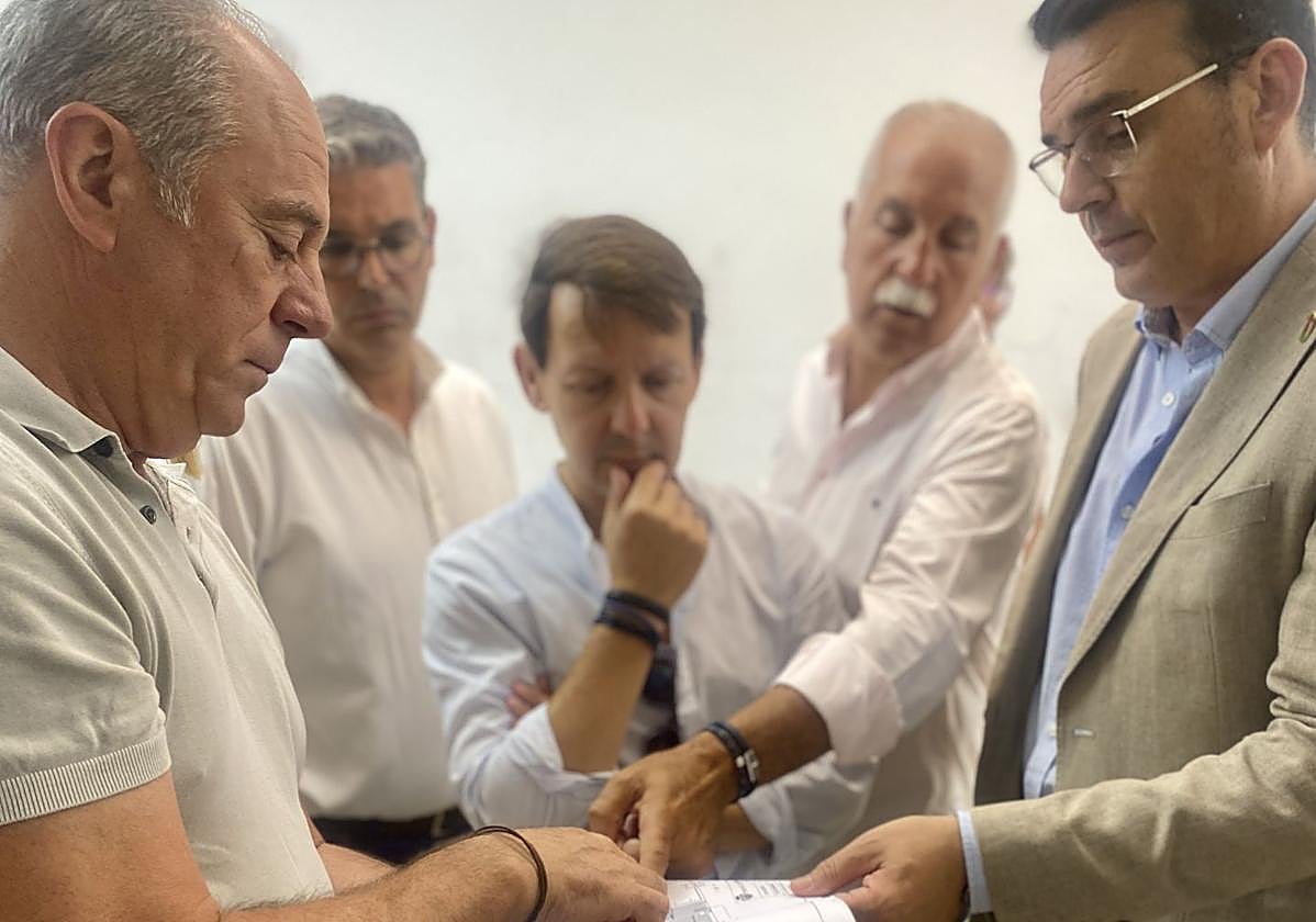 El alcalde de Mutxamel, Rafael García Berenguer, revisa los plano de la nueva oficina de SUMA en la localidad.