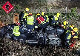 Los bomberos actuando en el coche.