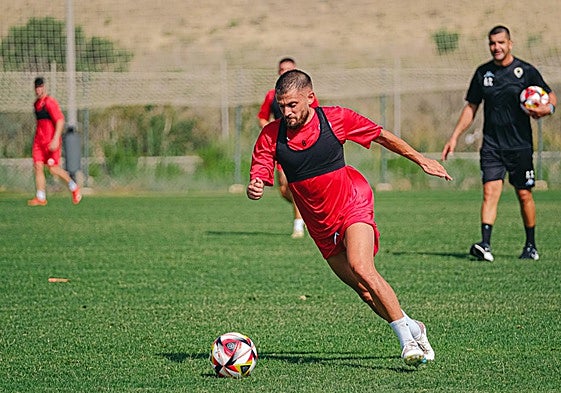 José Artiles conduce el balón ante la mirada de Torrecilla.