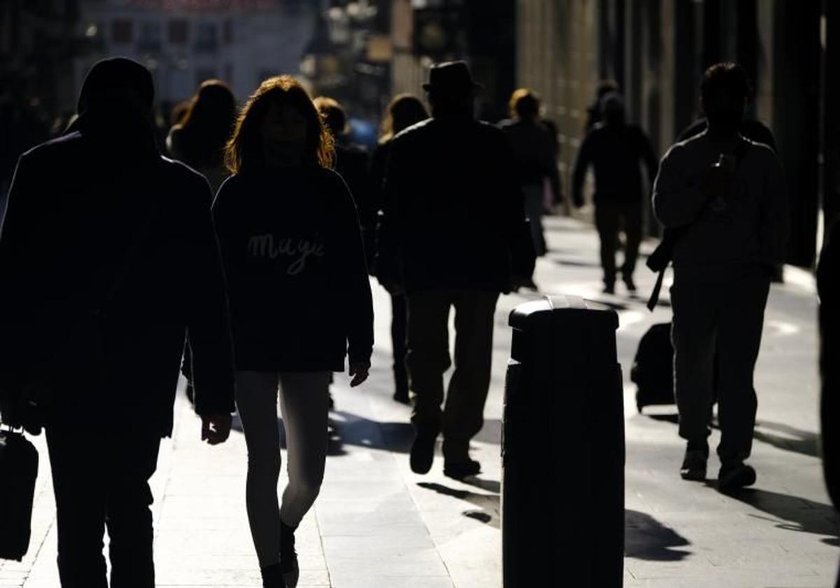 Un grupo de personas andando por la calle.