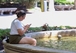 Una mujer con los pies metidos en una fuente.
