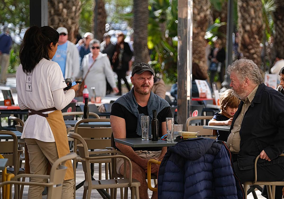 Una camarera atiende una mesa en la Explanada.