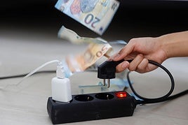 Una persona enchufando un aparato eléctrico a una regleta.