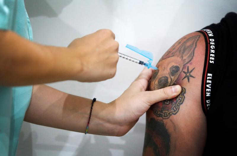 Personal sanitario vacunando a un joven.