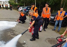 Miembros del cuerpo de Protección Civil usando extintores.