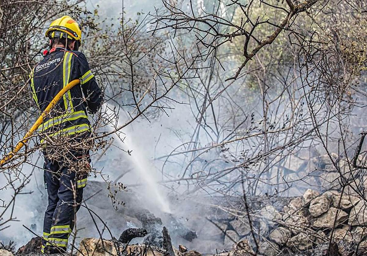 Un bombero del Consorcio Provincial refresca una zona de monte.