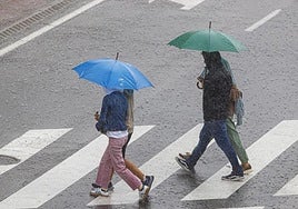 Transeúntes paseando por las calles de Valencia, este sábado.
