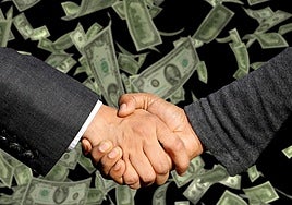 Dos hombres acuerdan un traspaso de dinero.