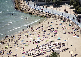 Bañistas disfrutan de la playa del Postiguet.