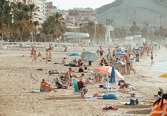 Bañistas disfrutan de la playa del Postiguet de Alicante recién entrado el otoño.