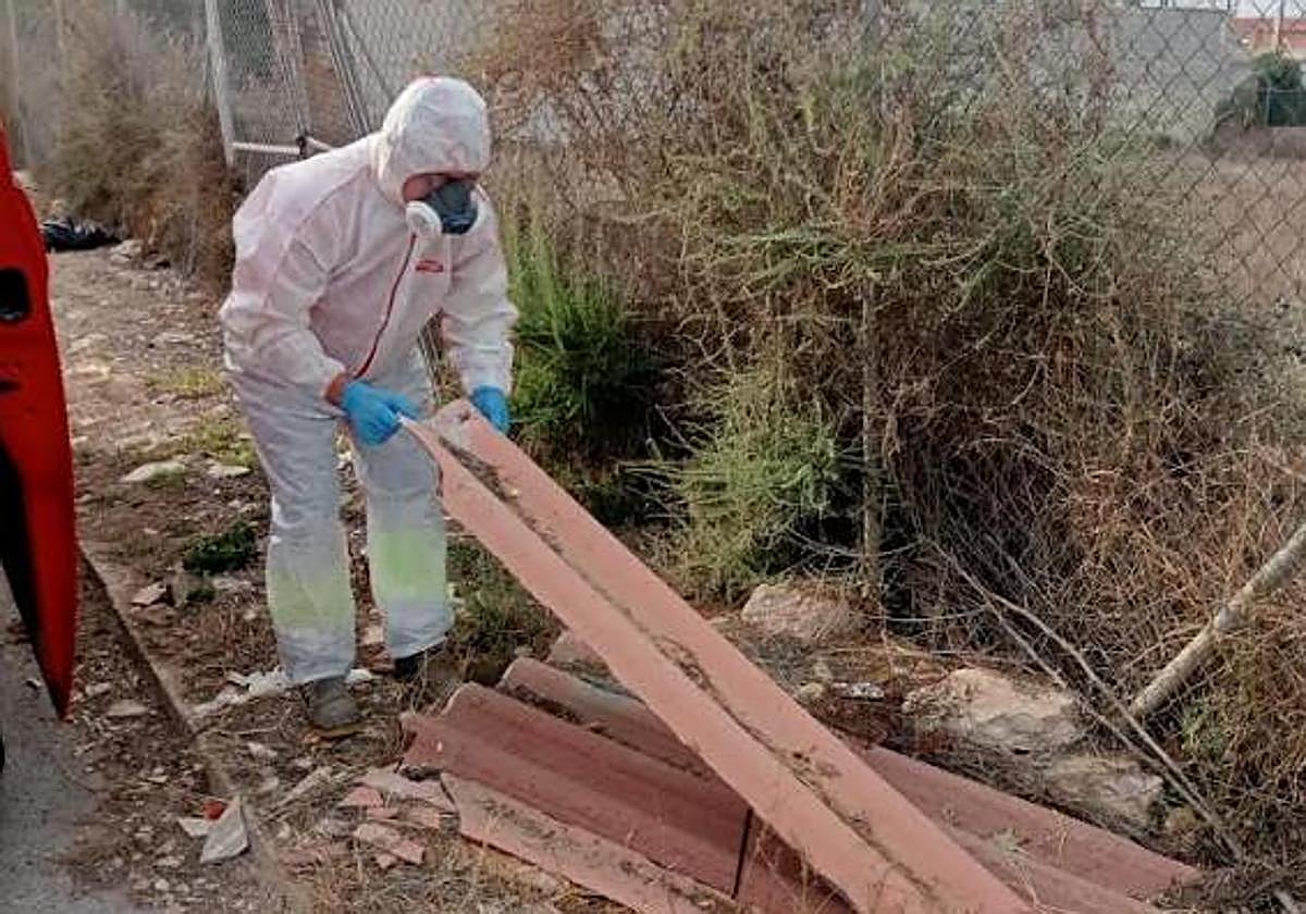 Un trabajador retira amianto de un emplazamiento.