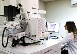 Investigadora en un microscopio electrónico.