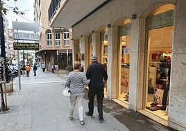 Una pareja paseo por delante de una tienda en Calp.