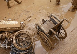 Sillas de ruedas cubiertas de lodo en una calle de Masanasa.