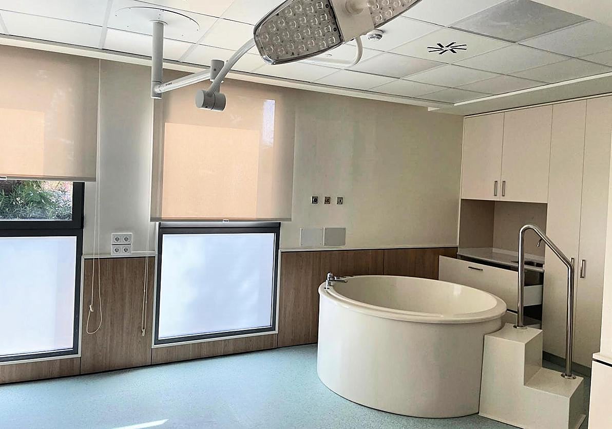 Imagen principal - (arriba) Sala de nacimiento Albufereta del Hospital Sant Joan d'Alacant con bañera de dilatación. (abajo) Cayetana Nely, primer bebé junto a sus padres Sara y Aurelio, la responsable de matronas, Isabel Robles y la directora médica, Lorena Peiró.