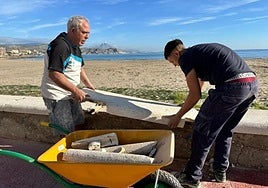 Dos operarios colocan una piedra en el murete del Carrer La Mar de El Campello.