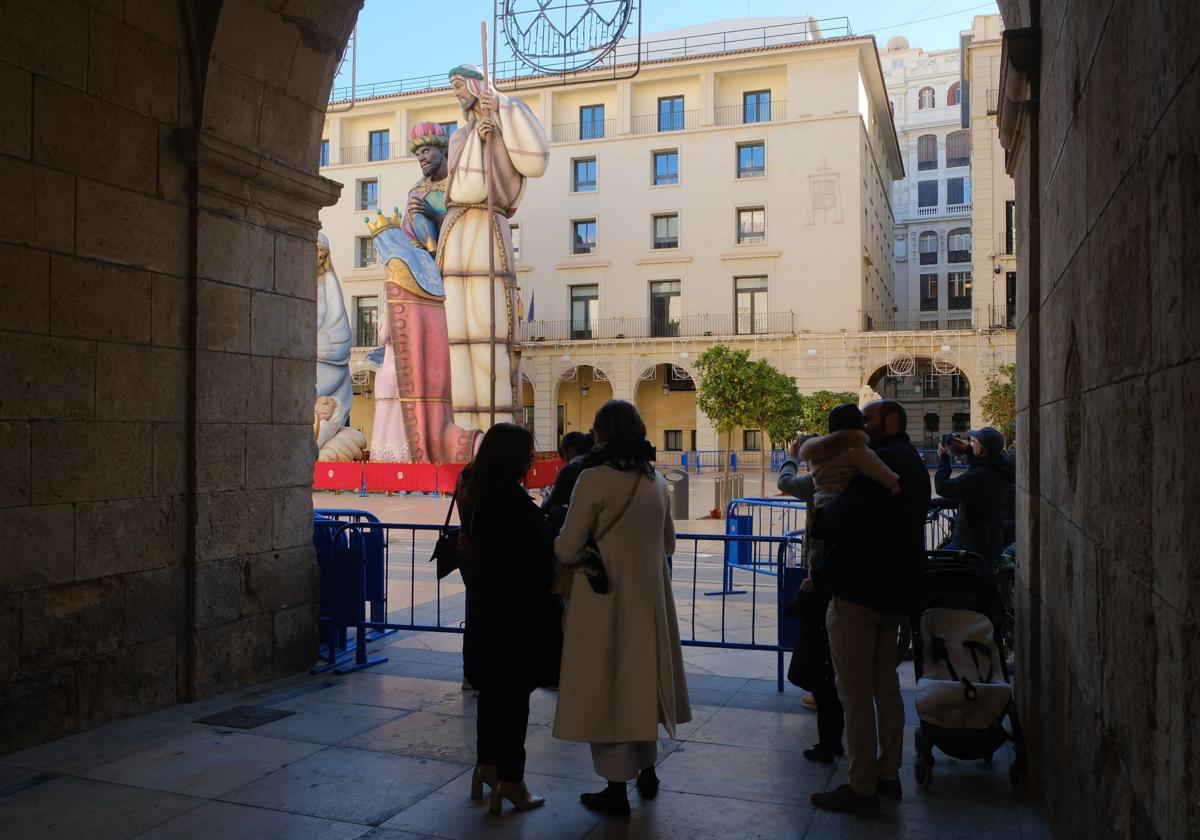 Varias personas observan el Belén Gigante bajo los soportales.