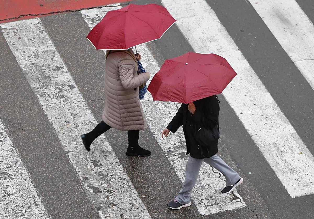 Several people shield themselves from the rain this Tuesday.