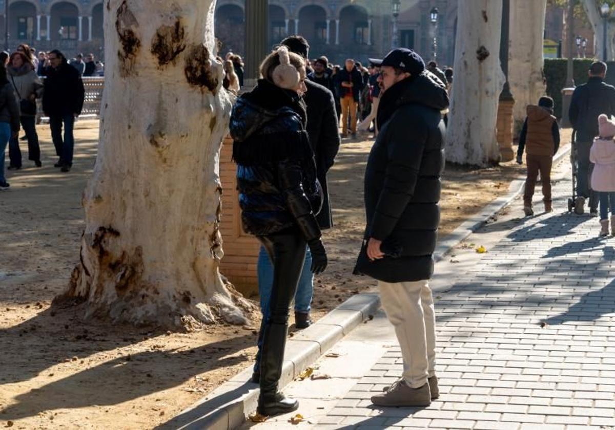 Personas abrigadas pasean por el parque.