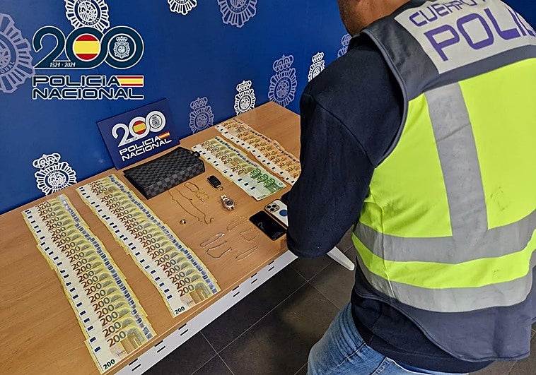 Los agentes de Policía, con el dinero incautado en la operación.