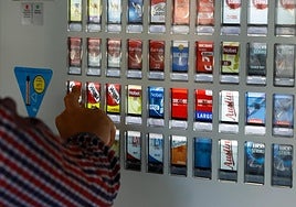 Un hombre compra una cajetilla de tabaco en una máquina expendedora