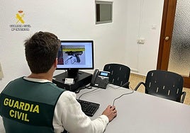 Un investigador observa imágenes de la pistola de plástico utilizada por los ladrones en el robo.