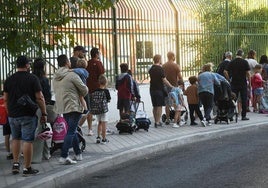 Padres y alumnos a la entrada de un colegio.