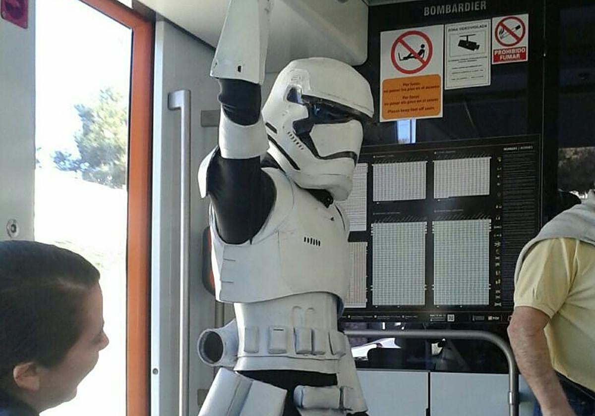 Una personas con un disfraz de soldado imperial de 'Star Wars' usando el Tram de Alicante.