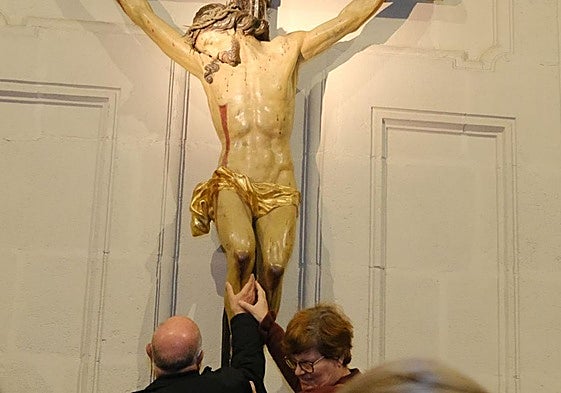 Dos de los participantes en la iniciativa tocan una imagen en la concatedral de San Nicolás.